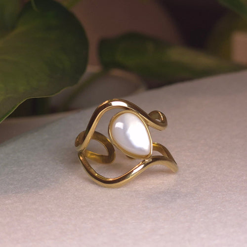 Bague dorée ajustable au design ondulé ajouré avec une pierre centrale en forme de goutte blanc nacré.